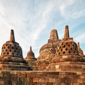 Stupas mit rautenförmigen und quadratischen Löchern und die oberste Hauptstupa im Borobudur, einem buddhistischen Tempel, Regierungsbezirk Magelang, Java, Indonesien.