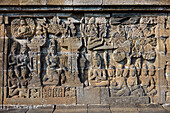 Reliefs on a corridor wall in the Borobudur, 9th-century Mahayana Buddhist temple. Magelang Regency, Java, Indonesia.