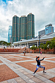 Asian woman practices tai chi in the Kowloon Park in the morning. Tsim Sha Tsui, Kowloon, Hong Kong, China.