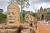 Large carved stone figures at the South Gate to the Angkor Thom. Angkor Archaeological Park, Siem Reap Province, Cambodia.