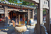 Large bronze urn with burning incense sticks at the A-Ma Temple. Macau, China.