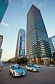 Electric taxi cabs move in the street in Futian Central Business District. Shenzhen, Guangdong Province, China.