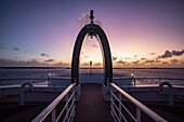 Krähennest am Bug des Expeditionskreuzfahrtschiffs SH Diana (Swan Hellenic) mit Aldabra am Horizont im Morgengrauen, Aldabra-Atoll, Äußere Seychellen, Seychellen, Indischer Ozean