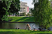  junge Leute am Ufer des Kanals rund um die Altstadt von Riga, vor der Nationaloper, Lettland, Baltikum, Nordeuropa 