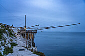  Historic stilt house of the fishermen Trabucco on the coast of Vieste at dusk, Gargano, Apulia, Italy, Europe 