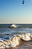 A kiteboarder being pulled across the water by a power kite. Mui Ne, Binh Thuan Province, Vietnam.