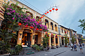 People walk in in Hoi An Ancient Town illuminated at dusk. Quang Nam Province, Vietnam.