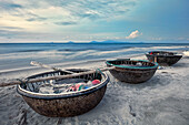 Traditional Vietnamese coracles on Cua Dai Beach at dusk. Hoi An, Quang Nam Province, Vietnam.