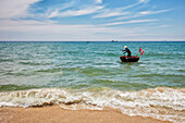 Vietnamese coracle fisherman. Cua Dai beach, Hoi An, Quang Nam Province, Vietnam.