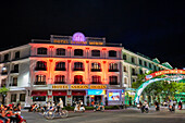 Exterior view of the Saigon Morin Hotel, a luxury colonial-era hotel, colorfully illuminated at night. Hue, Vietnam.