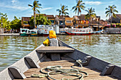 Bow of a traditional boat moving across the Thu Bon River. Hoi An, Quang Nam Province, Vietnam.