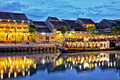  Alte Häuser entlang des Flusses Thu Bon in der Altstadt von Hoi An, beleuchtet in der Abenddämmerung. Hoi An, Provinz Quang Nam, Vietnam. 