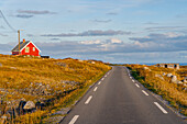 Norwegen, Finnmark, Varangerhalvøya, Hamningberg, Straße und rotes Holzhaus