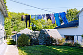  Amish House with clothesline and clothes to dry and springhouse in the Amish Village in Pennsylvania Dutch Country, Lancaster County, Pennsylvania, USA 