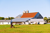  Landscape with farm and grain silo and Amish working in the fields near Strasburg in the Pennsylvania Dutch Country in Pennsylvania, USA 