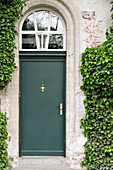  Dark green front door on ivy-covered facade 