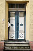  colorful front door on yellow house 