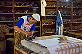 workers applying wax-resist using a copper plate stamp (cap), Wirakuto batik workshop, Pekalongan, Java island, Indonesia, Southeast Asia