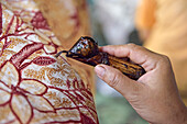 woman using a pen-like tool, called "canting", to apply liquid hot wax to create pattern on the fabric before dyeing, workshop of Kidang Mas Batik House, Lasem, Java island, Indonesia, Southeast Asia