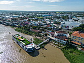  Aerial view of river cruise ship RV Mekong Discovery next to the pier on Hau River with the city behind, Chau Phong, Tan Chau, An Giang, Vietnam, Asia 