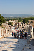 Visitors walk down the Curetes Street in ancient city of Ephesus, a UNESCO World Heritage Site. Ephesus Archaeological Site, Izmir Province, Turkey.