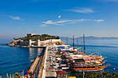 Boats moored at pier near the Castle on Pigeon Island. Kusadasi, Aydin Province, Turkey.