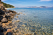 A rocky beach with crystal clear turquoise sea water at Dilek Peninsula National Park, Aydin Province, Turkey.