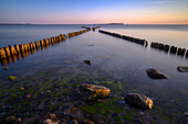  X-buhne, cross-buhne on the Baltic Sea beach Dranske at sunset with light reflections, golden hour, Baltic Sea, Baltic Sea island, Rügen, Germany\n 