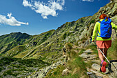  Woman hiking over rocky terrain on the GTA, GTA, Grande Traversée des Alpes, Biella, Alpi Biellesi, Valais Alps, Piedmont, Italy 