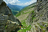  Several people hiking down through a rocky gorge, Ahrntal, Lausitzer Weg, Zillertal Alps, South Tyrol, Italy 