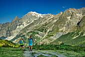 Mann und Frau wandern durchs Val Ferret, Mont Blanc im Hintergrund, Tour du Mont Blanc, Mont-Blanc-Gruppe, Grajische Alpen, Aostatal, Italien