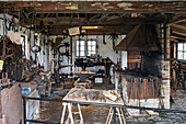 A vintage blacksmith workshop with tools, an anvil, and a forge.