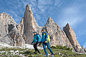 two hikers at the foot of the Tre Cime di Lavaredo (Three Peaks of Lavaredo), Three Peaks nature park, Trentino-Alto Adige, Sudtyrol, South Tyrol, Italy, South-central Europe