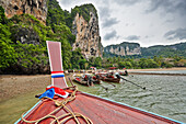 Bow of traditional Thai long-tail boat navigating Tonsai Bay near West Railay Beach. Krabi Province, Thailand.