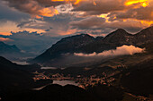 Beautiful Aerial View over Alpine Lakes and Swiss Alps and Cityscape in Sunset and Storm Clouds over St Moritz, Maloja, Grisons, Switzerland.