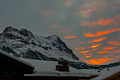 Berggipfel Eiger über den Dächern bei Sonnenuntergang in Grindelwald, Kanton Bern, Schweiz