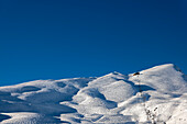 Ski Slope with Overhead Cable Car at 2000 Meters High Up and Mountain Peak in a Sunny Winter Day with Blue Clear Sky in Kleine Scheidegg, Bernese Oberland, Grindelwald, Canton Bern, Switzerland.