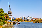 River Walk mit historischem Hafenkran am Christina River und Blick auf Downtown Wilmington, New Castle County Delaware, USA