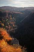  Hikers standing on rocks and looking at autumnal landscape at Traifelberg opposite Lichtenstein Castle, Hohnau, Lichtenstein, Reutlingen district, Swabian Alb, Baden-Württemberg, Germany, Europe 