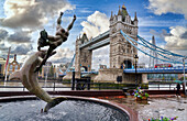Girl with Dolphin fountain on the north bank of the Thames river, Tower Bridge, London, England, UK