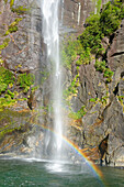 Rainbow over waterfall, Milford Sound, Fiordland National Park, South Island, Southland, New Zealand