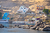 View of the riverbank of the nile in Aswan Egypt featuring colorful Nubian houses