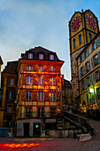 Street in Old Town with House and Clock Tower Illuminated in Dusk in City of Neuchatel, Canton Neuchatel, Switzerland.