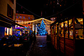 Altstädter Ring mit Restaurant und Weihnachtsbaum mit Lichterketten bei Nacht, Stadt Neuchâtel (Neuenburg), Kanton Neuchatel (Neuenburg), Schweiz.