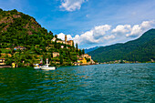 Nautical Vessel on Lake Lugano and House and Church on Mountain Range in a Sunny Summer Day on the Waterfront in Morcote, Lugano, Ticino, Switzerland.