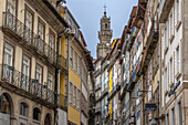  Tall canyons of buildings in Porto&#39;s old town. Colorful facades. Church tower in the background, Portugal 