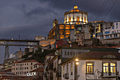  Evening view of part of the Ponte Luis I bridge and the Mosteiro da Serra do Pilar monastery on the south bank of the Douro River. Sandeman advertising sign, Porto, Portugal 