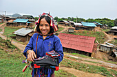 Woman from Akha Puli tribe wearing a headdress decorated with old French Indo-China silver coins, living in village in the mountains surrounding Muang La, Oudomxay Province in northwestern Laos, Southeast Asia
