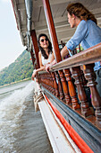 Junge Frauen an der Reling eines Hausbootes, bei der 'Luang Say Lodge', Fluss Mekong in Luang Prabang, Nordlaos, Laos, Südostasien