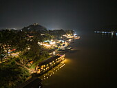  Aerial view of the boutique river cruise ship Anouvong (Heritage Line) moored on the upper Mekong River with city lights at night, Luang Prabang, Luang Prabang District, Luang Prabang, Laos, Asia 